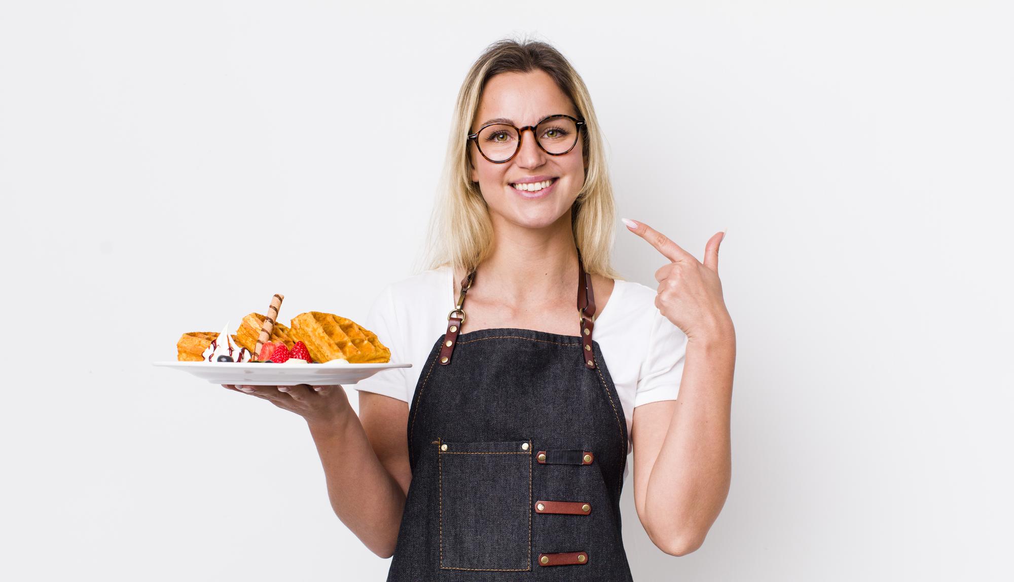 Friendly chef offering a dish in small studio kitchen