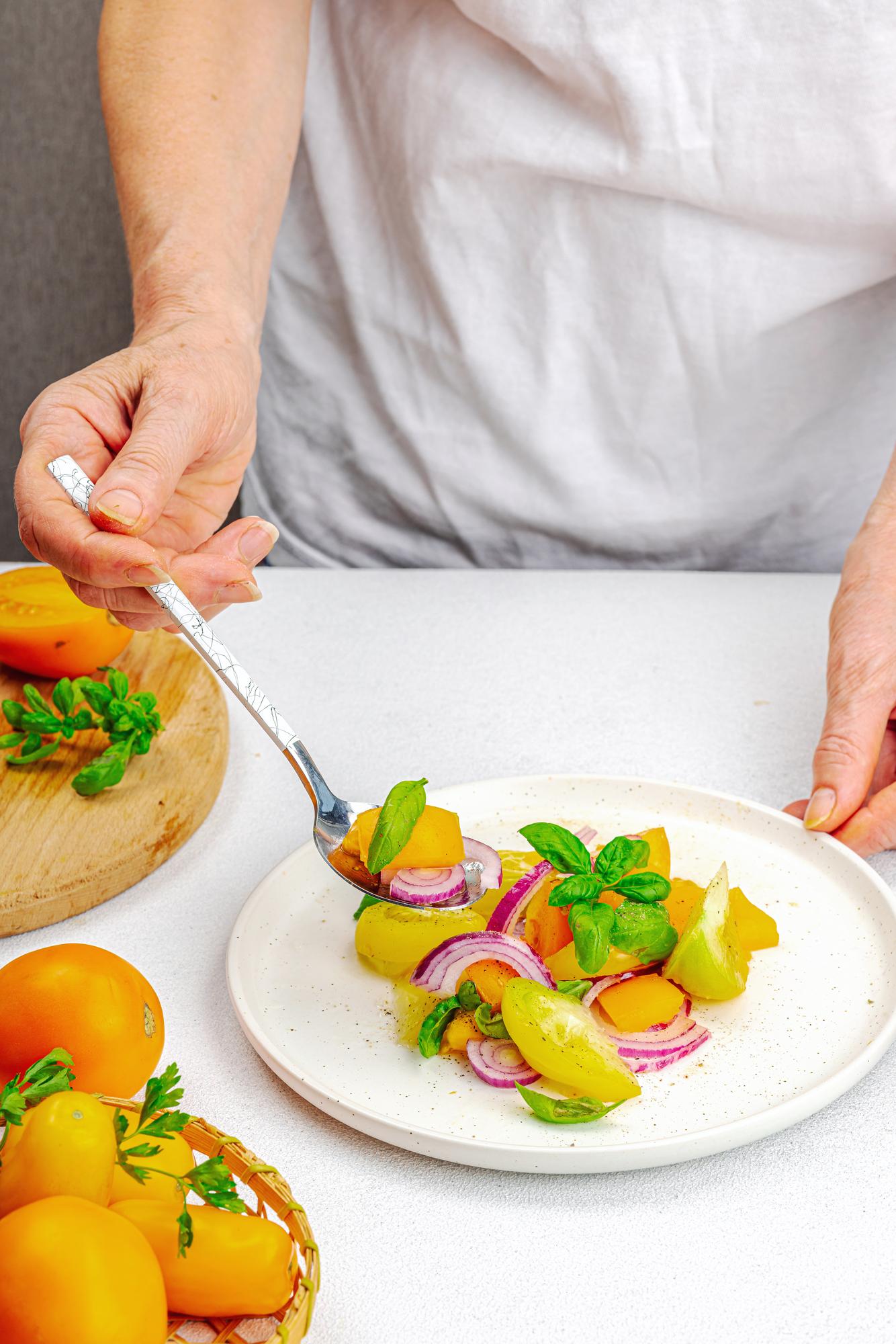 Chef preparing plated seasonal dish on wooden table